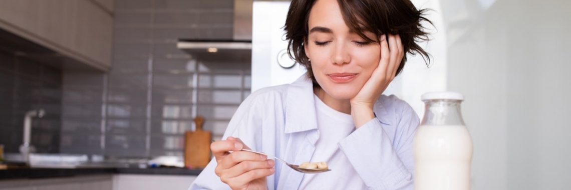 a woman sitting at a table with a plate of food